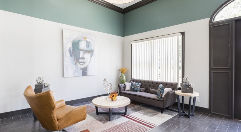 a living room with a couch, coffee table and art at The Lorenzo